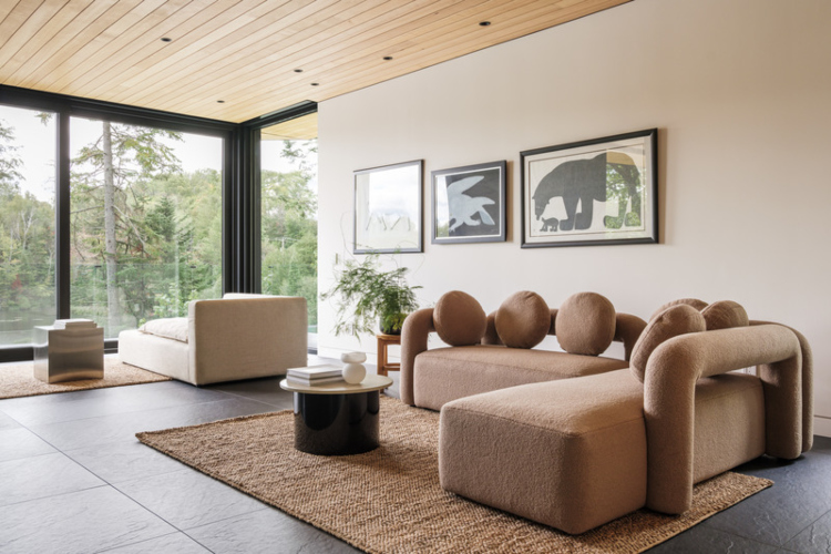 Veliki dnevni boravak sa udobnim nameštajem u neutralnim nijansama i pogledom na jezero